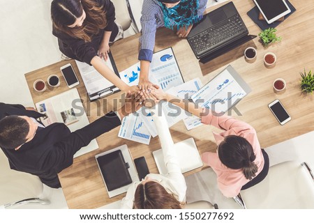 Businessmen and businesswomen joining hands in group meeting at multicultural office room showing teamwork, support and unity in business. Diversity workplace and corporate people working concept. Royalty-Free Stock Photo #1550277692