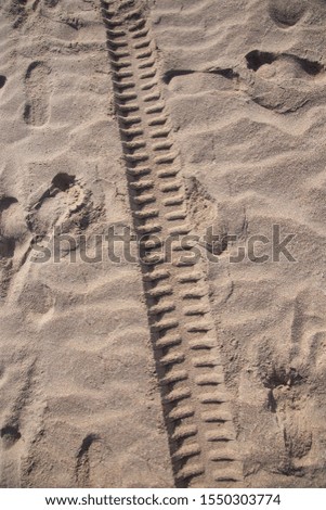 Deep trail of tread on the sand closeup