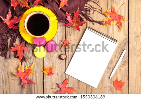 cup with black coffee, yellow lollipops, macaroons, notepad, wooden table with autumn fallen orange leaves Flat lay Top view Mock up Hello september, october, november, sesonal concept Rustic style