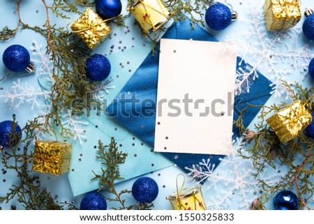 snowflakes with card invitation and envelope on blue. Christmas and new year tree balls and decor