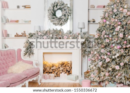 Modern design of the room with fireplace in light colors decorated with Christmas tree and decorative elements. New Year decorations, Happy Winter Holidays, Christmas tree and presents