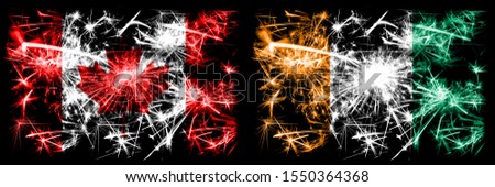 Canada, Canadian vs Ivory Coast New Year celebration sparkling fireworks flags concept background. Combination of two abstract states flags.
