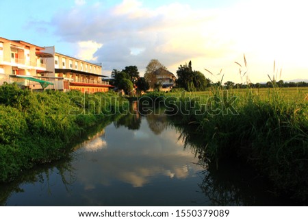 The house is adjacent to the river and rice fields.