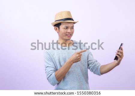 Happy  asian  man  shopping  with smart  phone  on  pink  background.