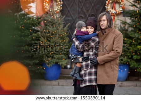 Christmas time. Happy Family - mother, father and little girl walking in city and having fun. Travel, tourism, holidays and people concept. Warsaw, Poland