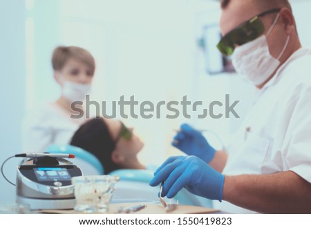 Man dentist working at his patients teeth