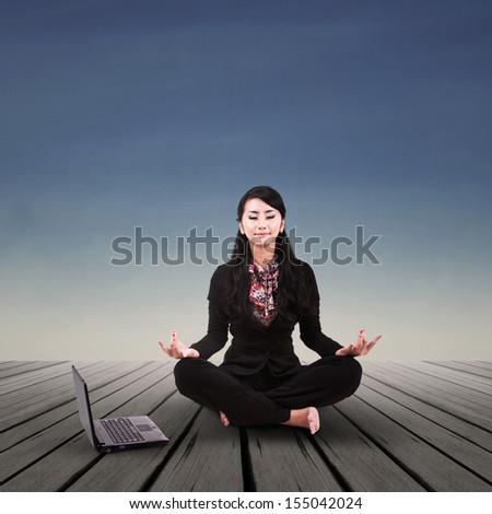 Asian businesswoman is meditating outdoor