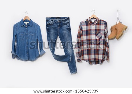long sleeve plaid shirt on hanging with blue jeans,jeans shirts and boots on white background
