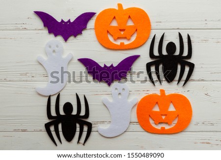 felt pumpking, spider, ghost, bat on wooden background