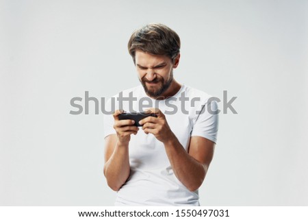 man with a mobile phone in his hand white t-shirt isolated background