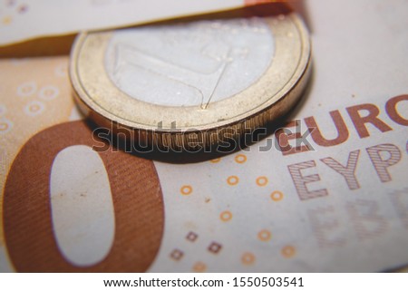 Macro photo of a coin in 1 Euro on a blurred background banknote in 50 euro. Money background. Extremely small depth of field.