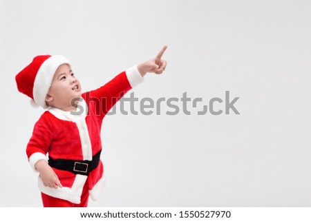 Asian baby boy in a Christmas costume Santa Claus pointing fingers and laughing isolated on white background, Happy and smile concept