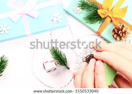 Christmas composition. Gift box. Orange ribbon. Snowflake. Hands