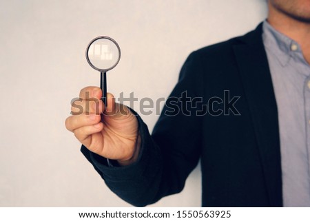 business man holding magnifying glass. concept of search