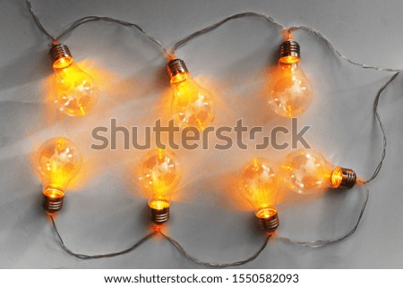 Light bulbs illuminated garland on light gray background