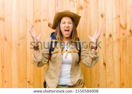 young latin explorer woman against wooden wall background