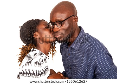 handsome young woman kissing her husband wearing his glasses on the cheek