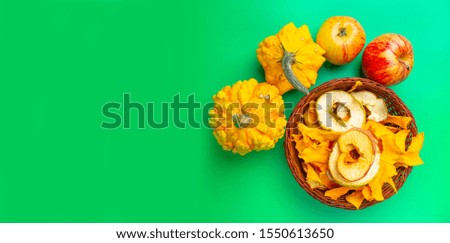 Healthy food concept. Mixed dehydrated pumpkin, apples chips on trendy mint background, with blank space for text. Top view, flat lay.