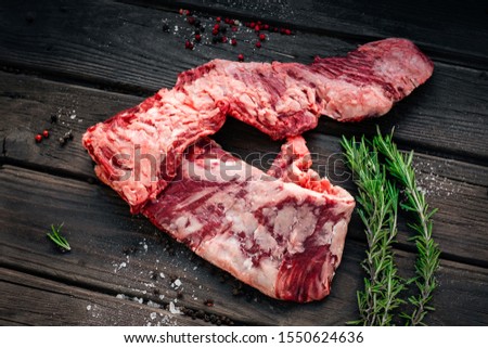 Raw machete beef steak with seasonings on old wooden background Royalty-Free Stock Photo #1550624636