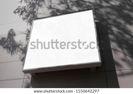 Mockup of the blank white street city outdoor advertising square logo sign on building wall