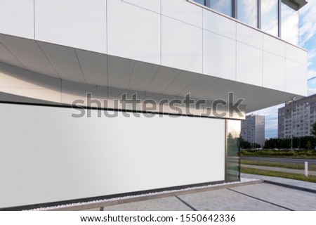 Mockup of the blank white street city outdoor advertising horizontal billboard in silver frame at corporate building window