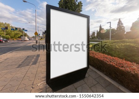 Mockup of the blank white street city outdoor advertising vertical billboard stand in black frame on sidewalk