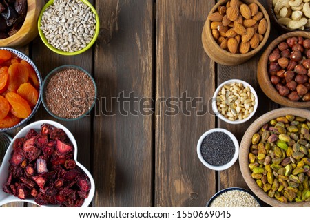 nuts, seeds and dried fruis on wooden surface