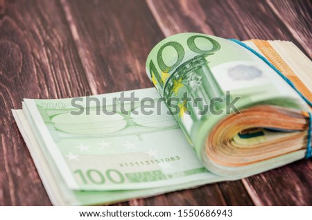 twisted euro banknotes on a wooden background. Close-up.