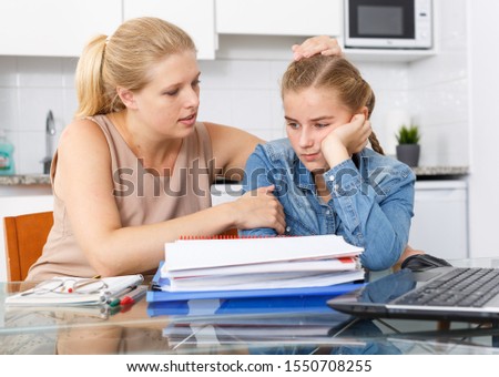 Adult woman supporting morally her daughter who upset by her studies  Royalty-Free Stock Photo #1550708255