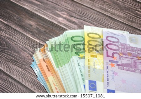 many euro banknotes on wooden background