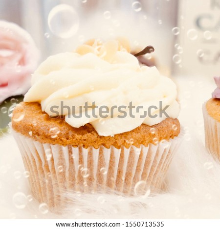 The lovely vanilla cupcakes are placed on a white carpet, with water droplets floating in the picture, the picture change warm retro mode.-image