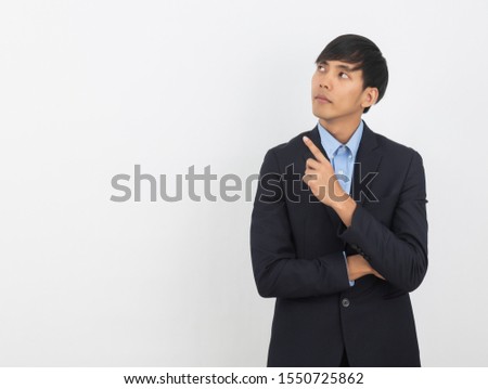 Young asian business man pointing to the side with a finger to present a product or an idea while looking forward isolated on white background.