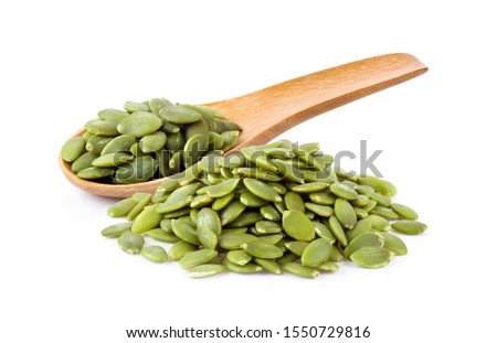 Pumpkin seeds in wood spoon  isolated on a white background. full depth of field