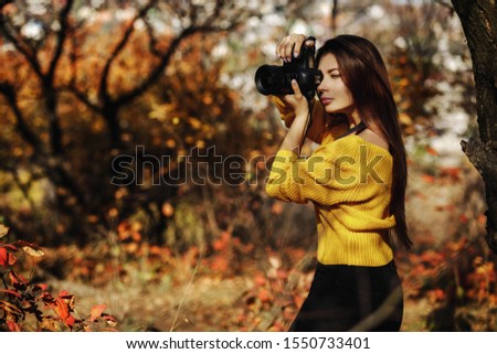 woman photographer takes pictures in autumn. space for text