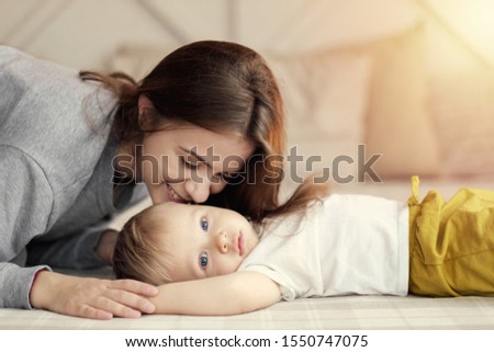 mother and child on bed, mum kiss her son, feelings, relationship of mother and child,