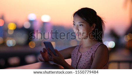Woman check the location on cellphone in city of Hong Kong at sunset time
