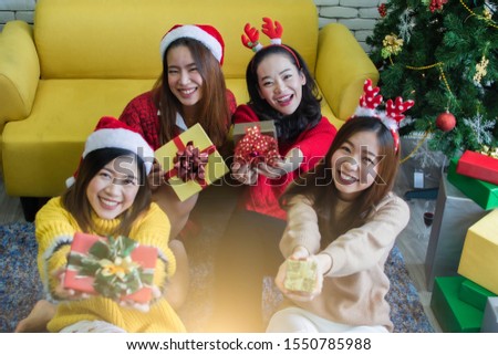 Beautiful asian women are smiling and holding gift boxes in Christmas or New Year Party