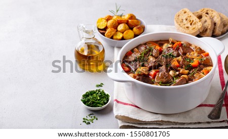 Beef bourguignon stew with vegetables. Grey background. Copy space. Royalty-Free Stock Photo #1550801705