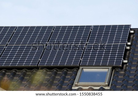 Modern blue solar panels on a house,  renewable energy photovoltaic panels on a roof. Close-up. 