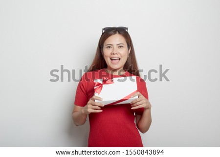 Attractive asian woman in a red dress holding christmas gift and new year  on light gray banner background, concept Black Friday and shopping , copy space for text