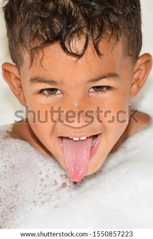 Mixed race boy having fun during bath time