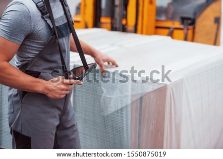 Portrait of young worker in unifrorm that is in warehouse.