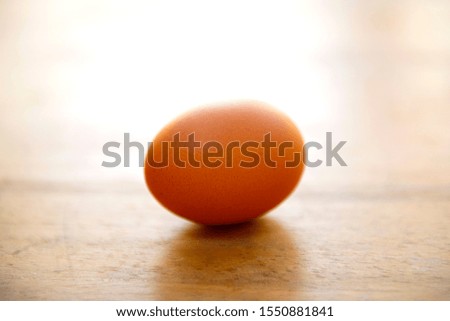 Raw single brown chicken egg isolated on a wood table, cooking healthy food   