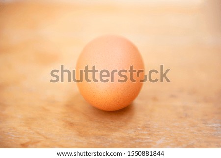 Raw single brown chicken egg isolated on a wood table, cooking healthy food   