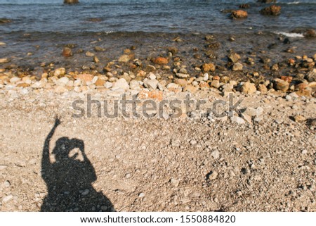 shadow of girl take a photo at sea