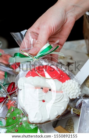 A woman holds in her palms her home-baked cookies, decorated with icing. Close-up. Concept - hobby, small business