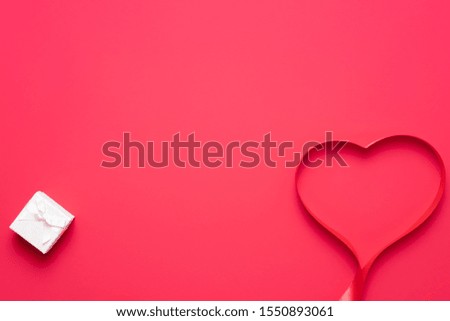 Top view of ribbon shaped as heart on red background. Valentine's Day concept