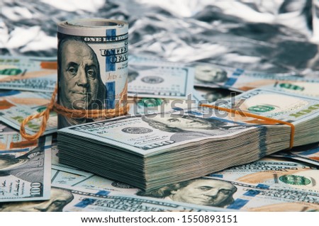 Cash hundred dollar bills, dollar background image. A stack and roll of one hundred American bills.