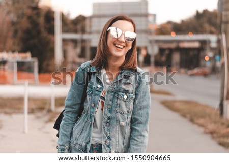 Fashionable girl laughing to camera while resting in summer day