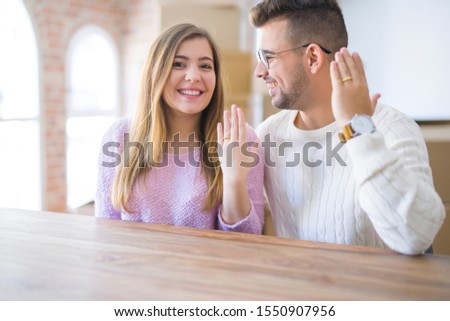 Young cheerful couple smiling happy showing wedding ring, celebrating engagement at home